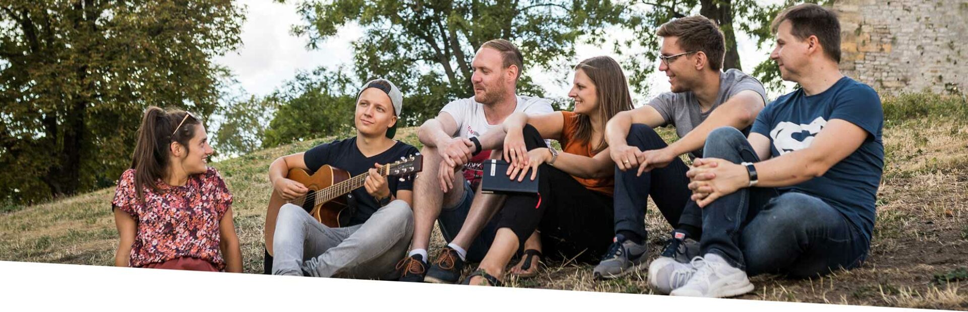 Eine Gruppe junger Menschen sitzt im Kreis und spricht miteinander